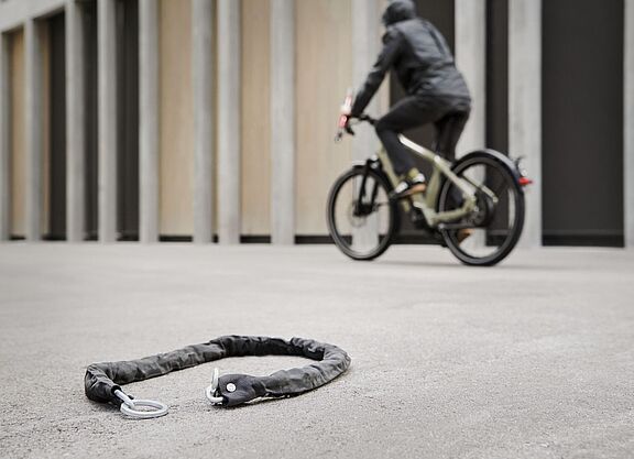 Vermeintlicher Fahrraddiebstahl Fahrradfahrer fährt an einem Fahrradschloss vorbei, das auf dem Boden liegt.