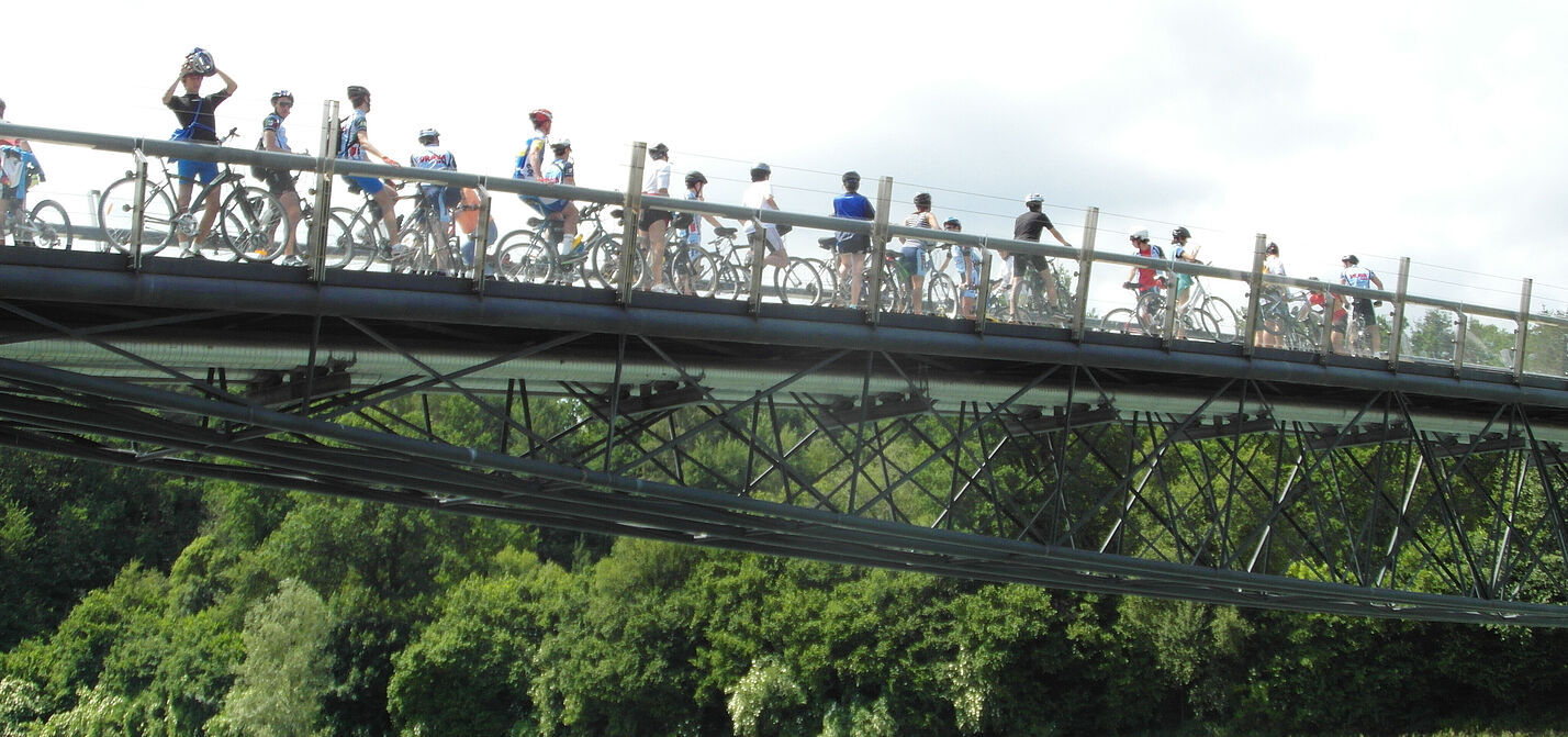 Radfahrerinnen auf Brücke über Fluss